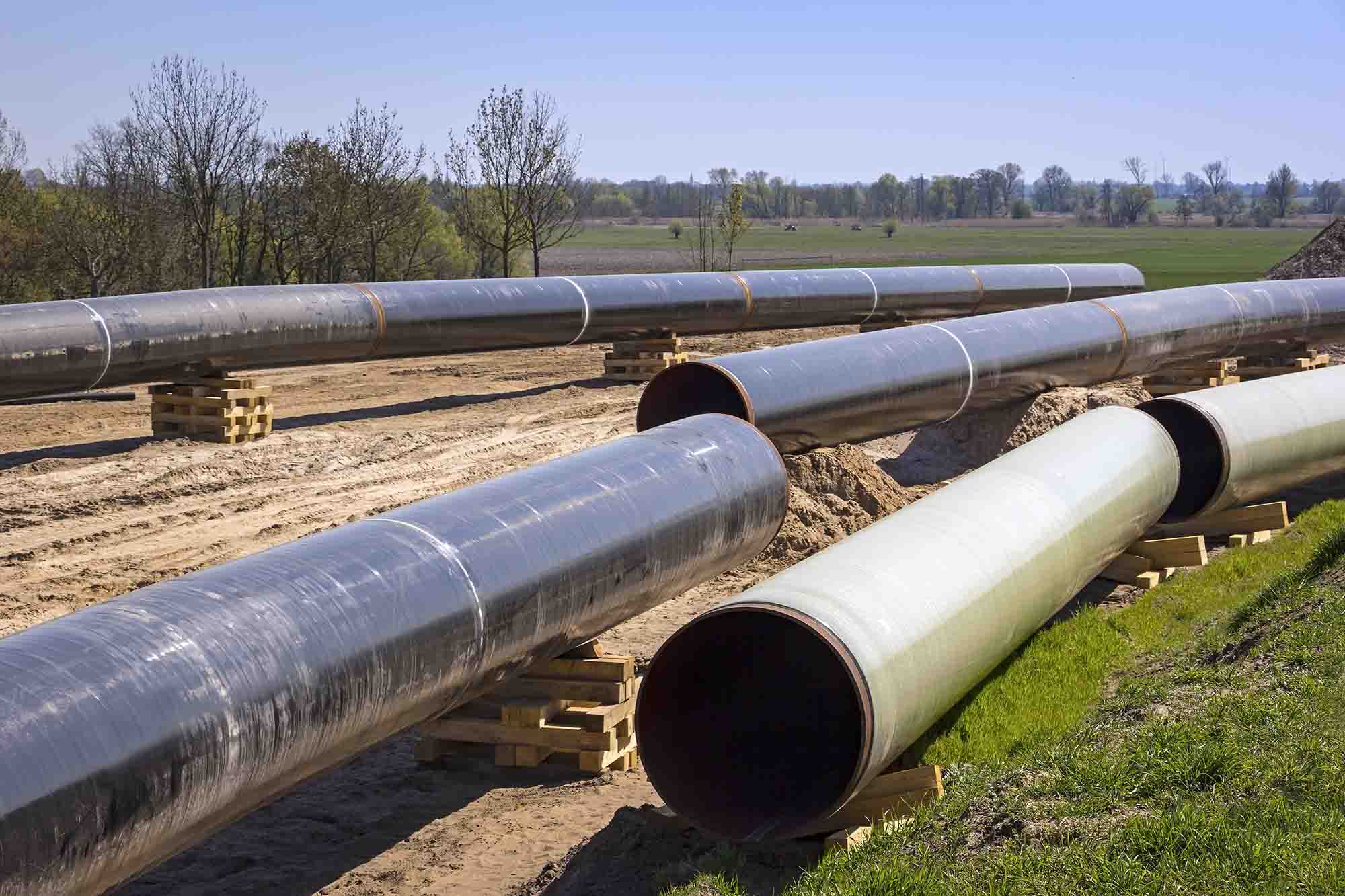 An image showing a large-diameter ductile iron pipe (DN350–DN2200) being lifted symmetrically with dual hooks equipped with soft protective materials to ensure even force distribution and prevent tilting.