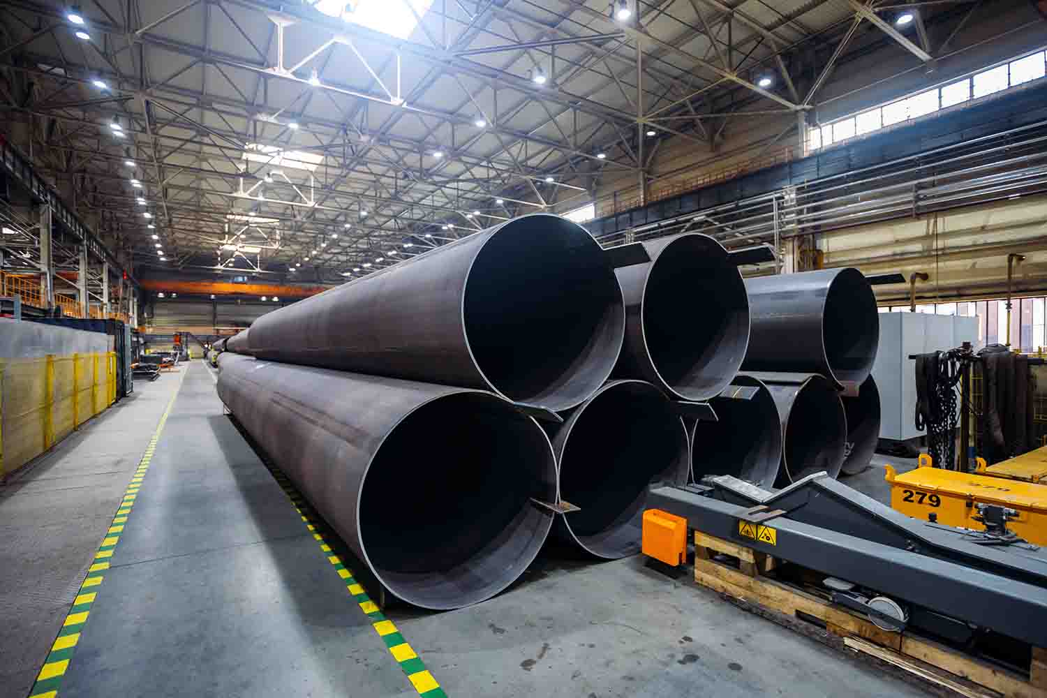 This image displays large-diameter ductile iron pipes stacked in a pyramid-style pattern. The pipes are stacked layer by layer in a decreasing manner, forming a stable pyramid shape. This stacking method enhances the overall stability of the pipe stack and is suitable for long-term storage.
