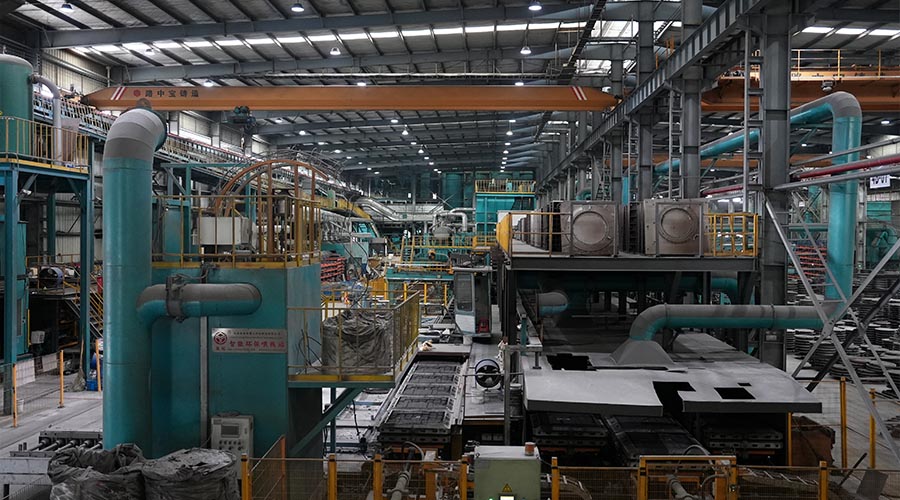 Production workshop scene of artistic manhole covers: Skilled workers inspecting the surface details of newly cast covers, ensuring the clarity of patterns and quality of materials in Tiegu's manufacturing process