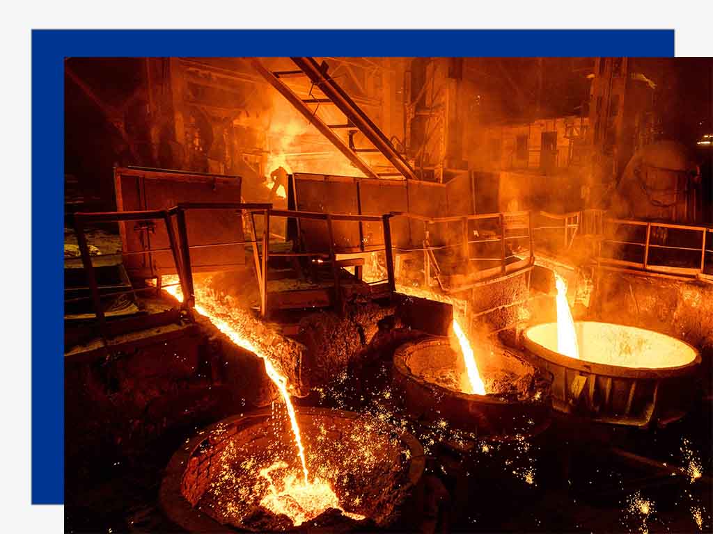 Workers charging iron ore, coke, and limestone into the blast furnace in layers