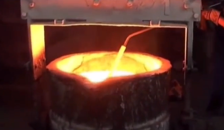 Molten iron pouring into sand mold during casting process